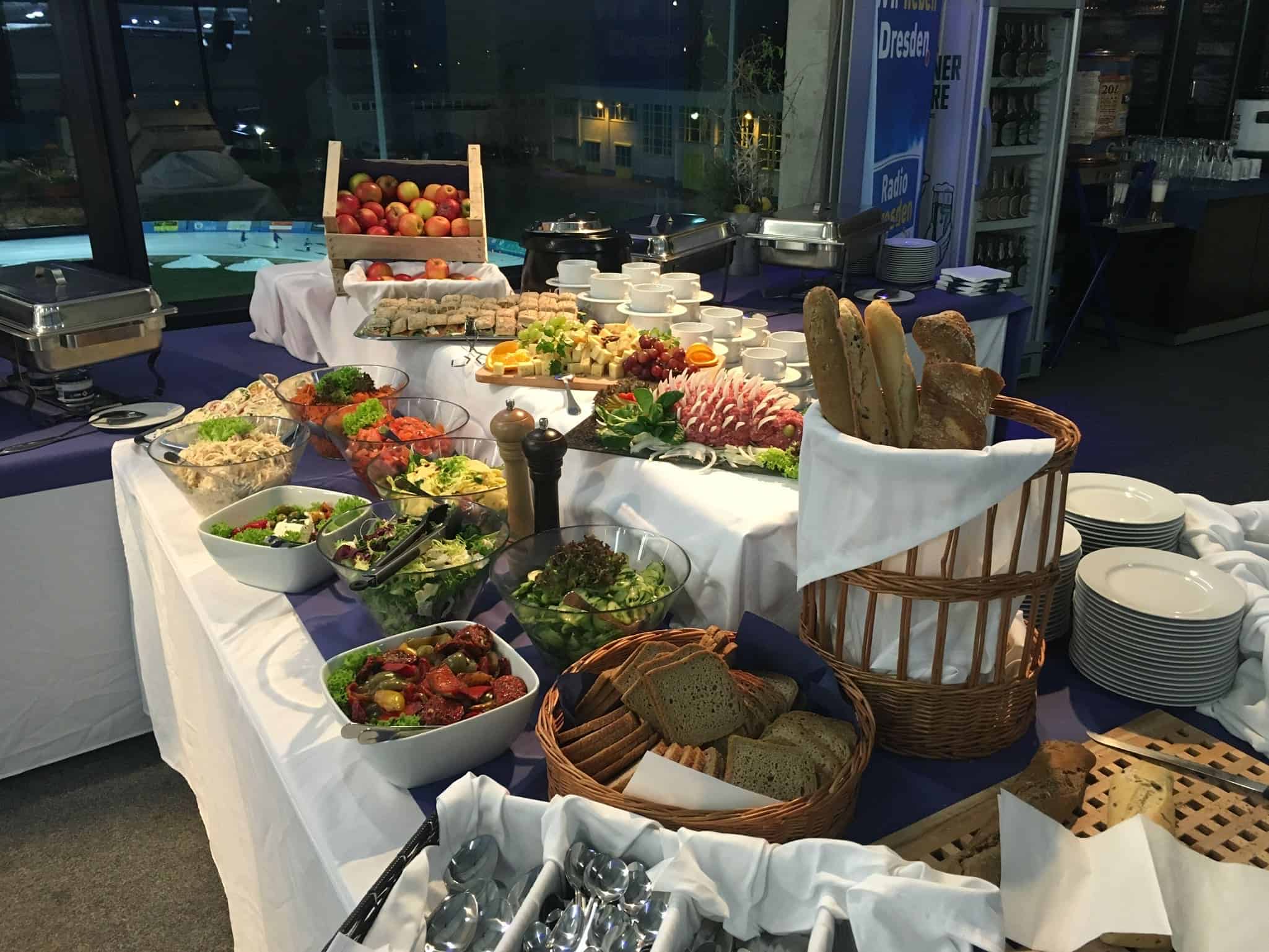 Buntes Buffet mit Salaten, Obst und Brotkörben