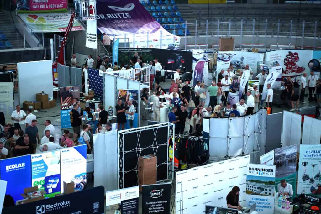 Blick von oben auf Messestände und Besucher in der Arena
