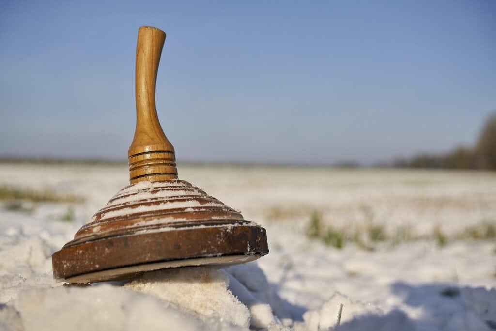 Hölzerner Eisstock im Schnee