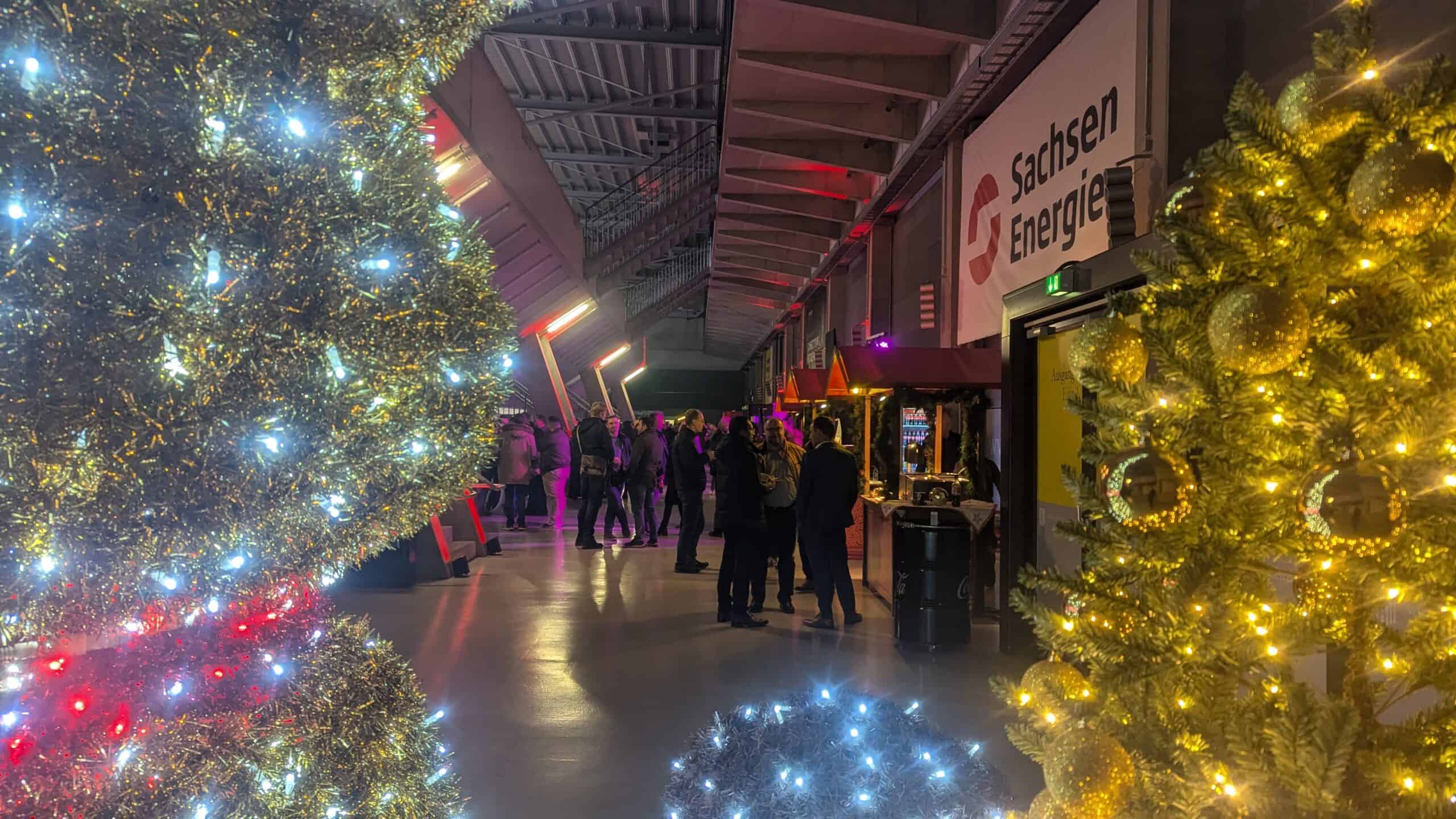 Weihnachtsfeier: beleuchteter Gang mit Lichterketten und Gästen